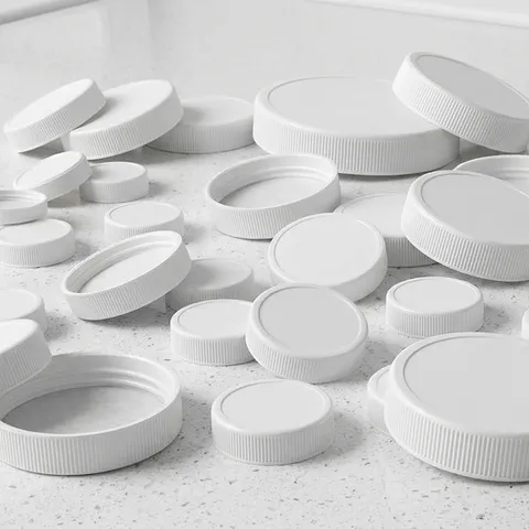 Assorted white screw caps in various sizes for water bottles